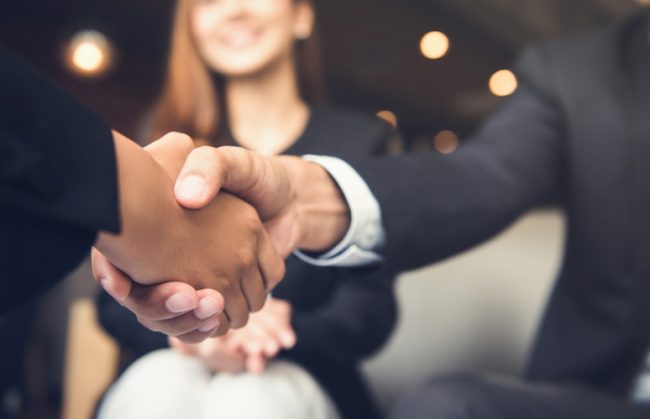 Businessmen shaking hands after meeting in a cafe