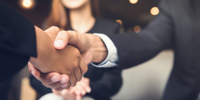 Businessmen shaking hands after meeting in a cafe